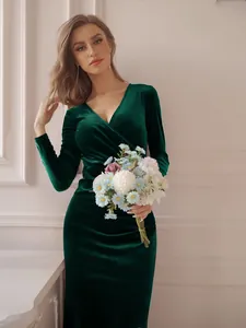 Elegant emerald green velvet evening dress with long sleeves and fishtail hemline