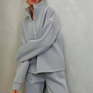 Dettaglio del set di felpa con collo alto e pantaloni sportivi grigio chiaro donna