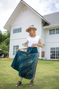 Detailed shot of bohemian peacock print maxi skirt in teal on model outdoors