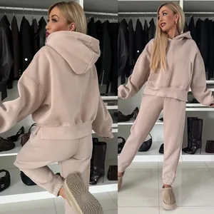 Beigefarbener Oversize-Kapuzenpullover und passende Jogginghose an einem Modell.