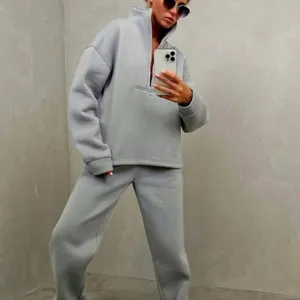 Dettaglio tuta da donna grigia con colletto rialzato elegante, felpa zip e jogger