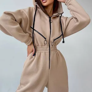 Nahaufnahme eines beigen Damen-Kapuzen-Overalls mit dekorativen Brust-Reißverschlüssen.