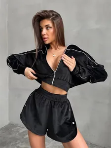 Two-piece black velvet tracksuit for women featuring cropped zip jacket and shorts.