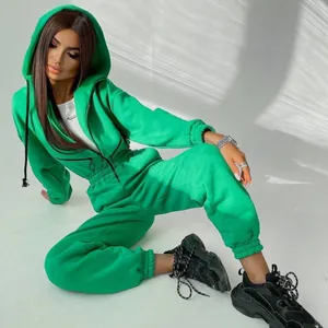 Leuchtend grüner Damen-Jumpsuit mit Kapuze und langen Ärmeln, sportlicher Freizeitstil.