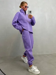 Modella che indossa una tuta casual viola da donna in un selfie allo specchio di moda.