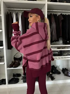 Detalle de la parte trasera de un conjunto de sudadera a rayas granate en un vestidor de lujo