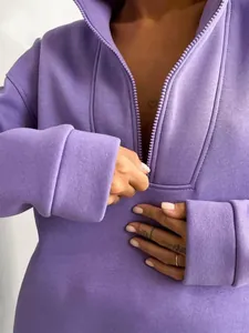 Dettaglio di una felpa viola con mezza zip, colletto rialzato e polsini a costine