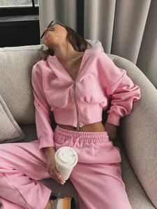 Detail view of a casual pink two-piece tracksuit set featuring zip-up hoodie and sweatpants
