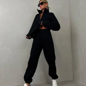 Foto a figura intera di una donna con felpa nera a collo alto e set di pantaloni jogger