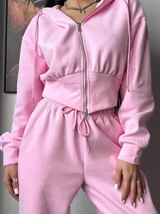 Detail of pink two-piece set featuring a slim zip-up hoodie and drawstring sweatpants