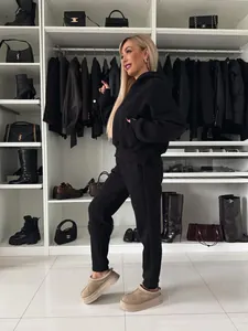 Frau im schwarzen Langarm-Kapuzenpullover und passendem Jogger-Set im Luxus-Kleiderschrank