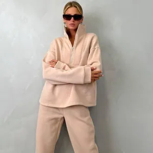 Vista dettagliata della felpa da donna con mezza zip e set di pantaloni pesca