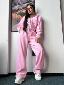 Detail of pink two-piece women's tracksuit with zip-up hoodie and wide-leg pants.