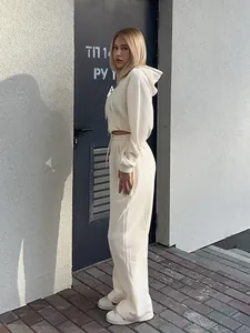 Side profile of a cream two-piece casual tracksuit with a cropped hoodie and wide-leg pants