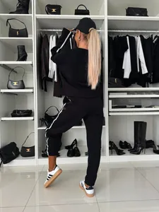 Rear view detail of black women's casual tracksuit set with white stripes in a luxury closet