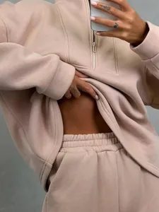 Primo piano di un set felpa con mezza zip e pantaloni sportivi beige da donna.