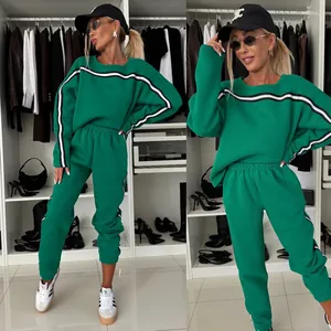 Detail view of a women's green tracksuit set with stylish black and white stripes