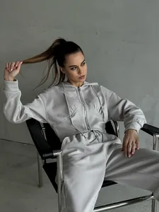 Detail shot of a stylish grey two-piece tracksuit featuring a zip-up hoodie and pants