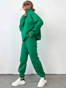 Vista laterale di una modella che indossa una tuta verde brillante con sneakers bianche.