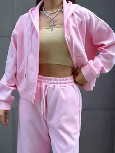 Detail of women's pink cotton tracksuit set featuring a zip-up hoodie and pants