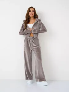 Grauer zweiteiliger Velours-Trainingsanzug für Damen mit Kapuzenjacke und weiter Hose.