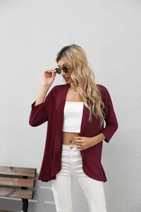 Modelo con un cárdigan burdeos de manga 3/4 combinado con un elegante top corto blanco