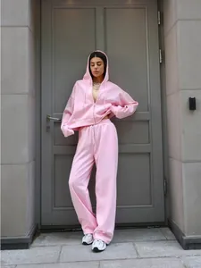 Stylish pink two-piece tracksuit for women featuring a hooded zip-up jacket and drawstring pants.