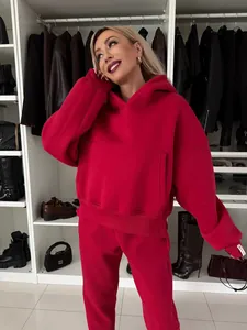 Detailansicht eines roten Kapuzenpullover- und Jogginghosen-Sets an einem Model im Schrank