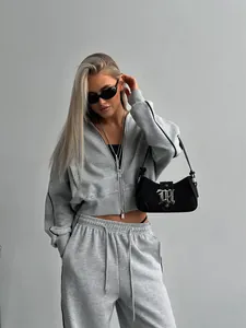 Détail d'un ensemble de survêtement gris deux pièces avec bandes latérales noires sur mannequin