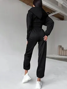 Vista posteriore dettagliata di una felpa con cappuccio nera sfiancata e pantaloni sportivi donna