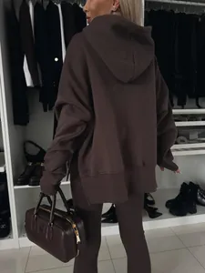 Vista trasera de una sudadera con capucha marrón de gran tamaño y leggings a juego