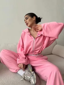 Women's pink two-piece tracksuit with zip-up hoodie and matching joggers shown on model