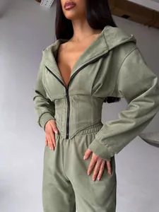 Dettaglio del set felpa con cappuccio a corsetto e dei pantaloni sportivi verdi