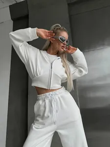 Stylish white two-piece lounge set featuring cropped zip-up hoodie and high-waist pants