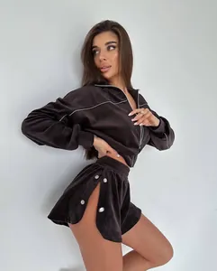 Detail of a women's chocolate brown velvet tracksuit set with zip jacket and side slit shorts