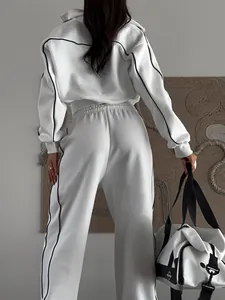 Vue arrière d'un survêtement blanc deux pièces avec détails de liseré noir contrasté