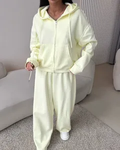 Full view of women's pale yellow tracksuit with zip-up hoodie and wide-leg sweatpants