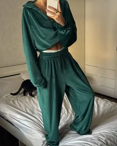 Detailed view of women's dark green velvet tracksuit set showing zip hoodie and jogger fit