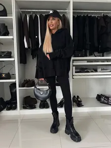 Primer plano de conjunto de sudadera negra con capucha en un fondo de vestidor de lujo