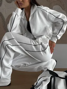 Vue détaillée du survêtement de sport blanc pour femmes avec rayures latérales noires