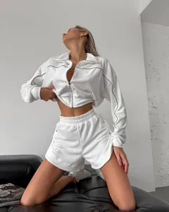 Detail view of a white two-piece lounge set with a zip-up jacket and matching shorts.
