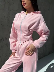 Vista dettagliata di una tuta in velluto rosa con felpa con cappuccio e vita a corsetto