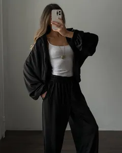 Full body mirror selfie of a women's black 2-piece loungewear set with zip hoodie.