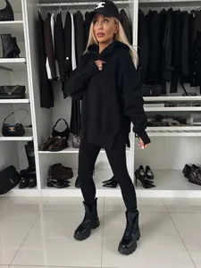 Conjunto de sudadera oversize con capucha y leggings negros en un vestidor de lujo