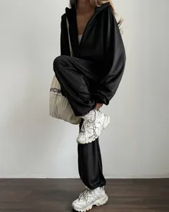 Detailed view of a black two-piece tracksuit set with a zip-up hoodie and joggers