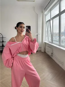 Woman in pink zip-up hoodie and matching sweatpants two-piece casual tracksuit set
