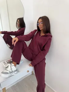 Detailed macro view of women's burgundy two-piece zip-up hoodie and pants tracksuit