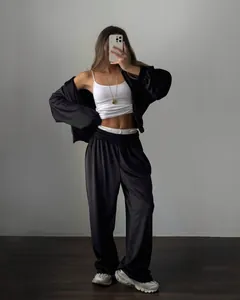 Minimalist black two-piece sporty set featuring crop zip-up jacket and wide-leg trousers