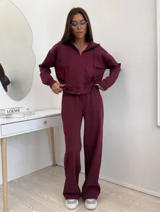 Women's maroon two-piece sports tracksuit with hooded zip-up jacket and wide-leg pants