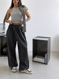 Detail view of dark gray wide-leg sweatpants with elastic waist for casual street style.